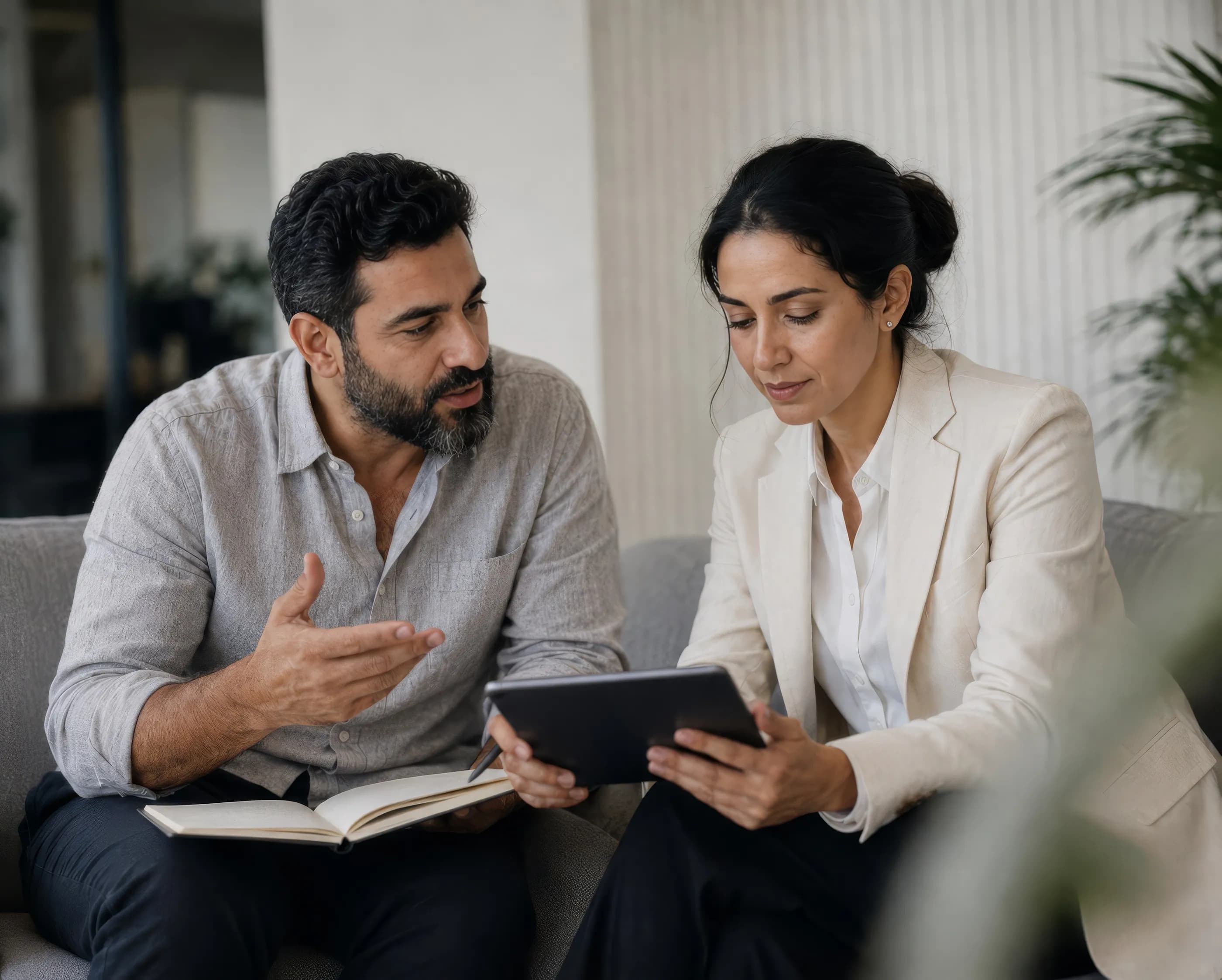 A man and woman reviewing an expense report together on a tablet