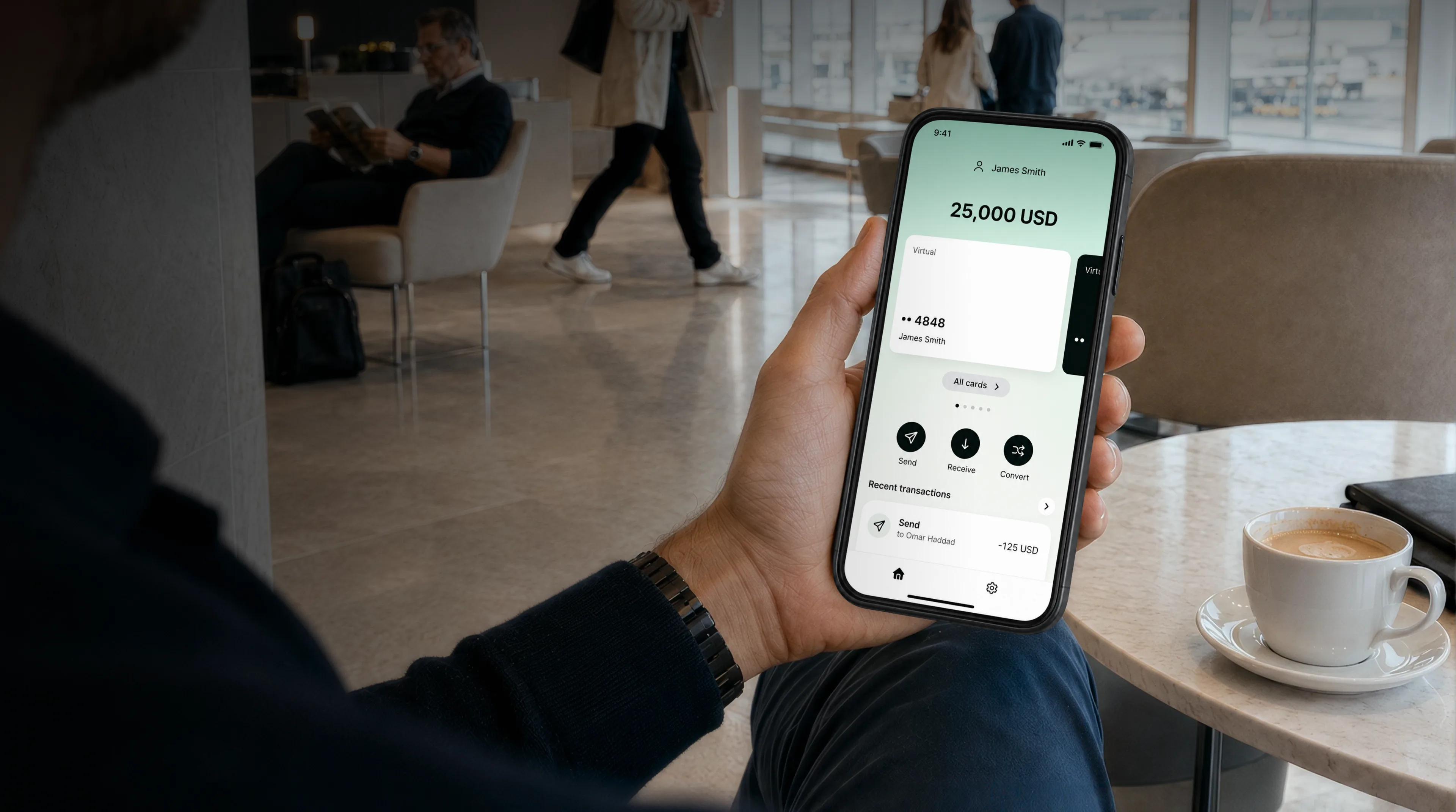 A man checking his Ortix balance on his phone in an airport lounge